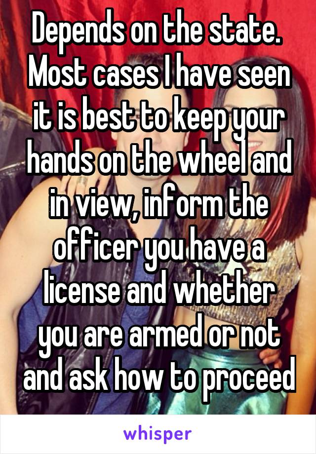 Depends on the state.  Most cases I have seen it is best to keep your hands on the wheel and in view, inform the officer you have a license and whether you are armed or not and ask how to proceed 