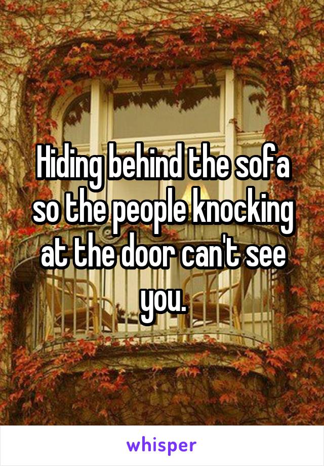 Hiding behind the sofa so the people knocking at the door can't see you.