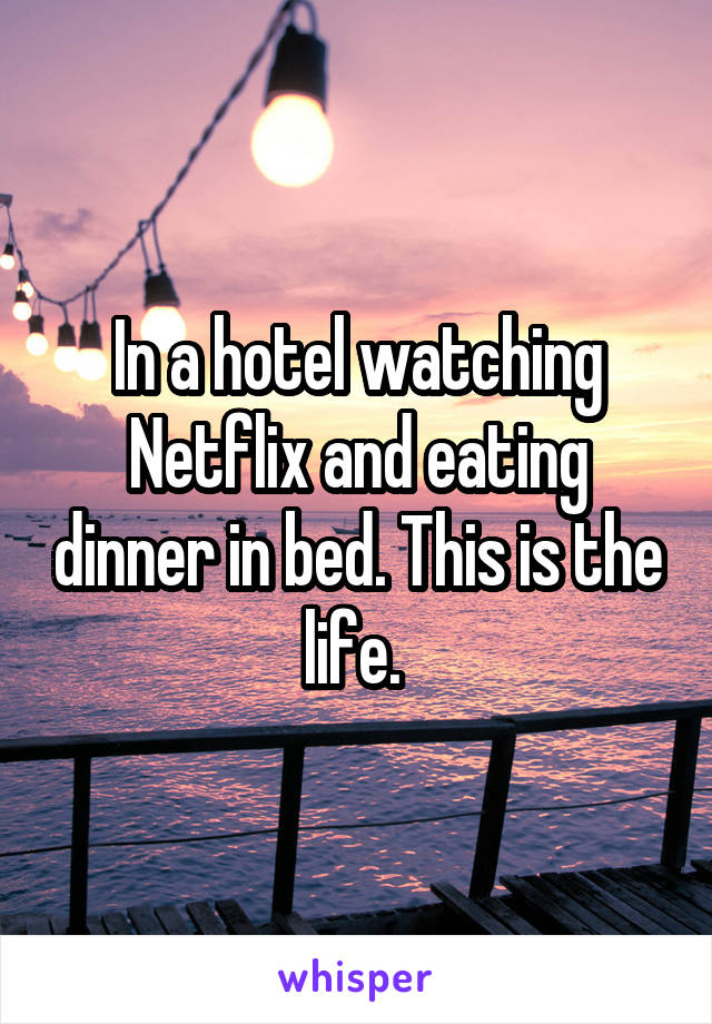 In a hotel watching Netflix and eating dinner in bed. This is the life. 