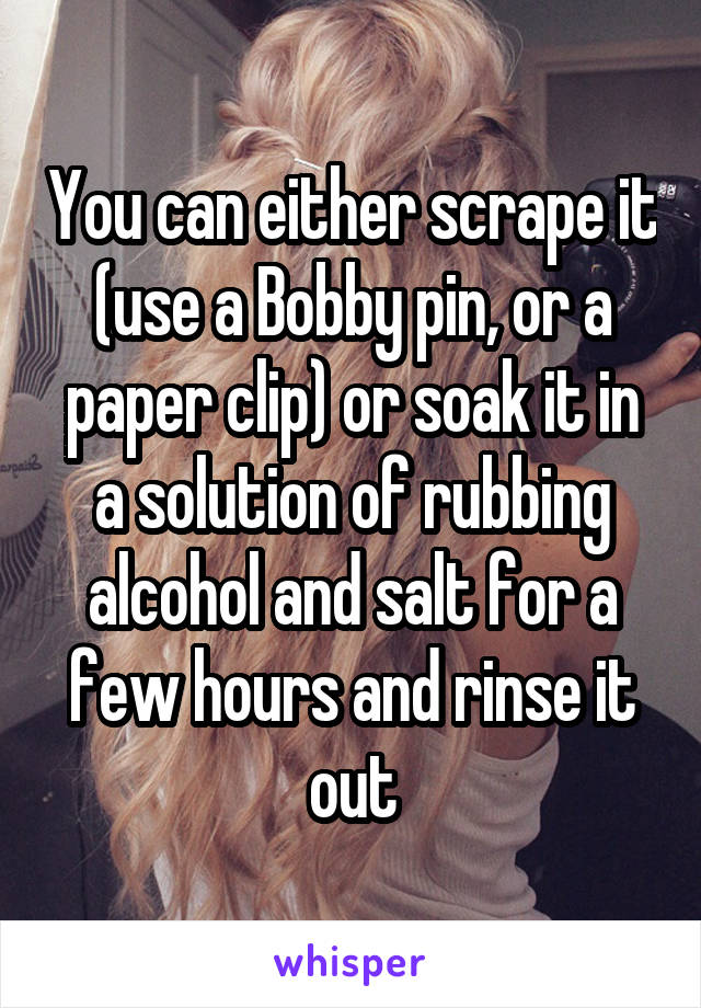 You can either scrape it (use a Bobby pin, or a paper clip) or soak it in a solution of rubbing alcohol and salt for a few hours and rinse it out