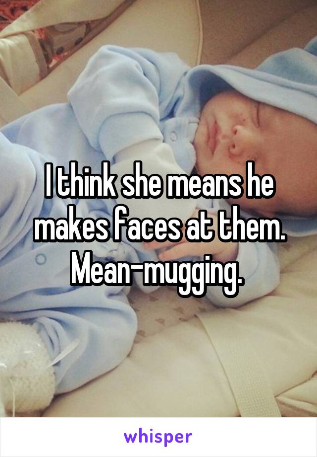 I think she means he makes faces at them. Mean-mugging. 