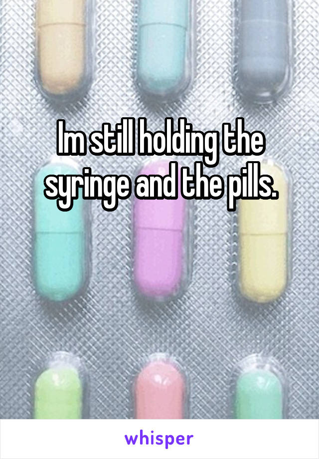Im still holding the syringe and the pills.


