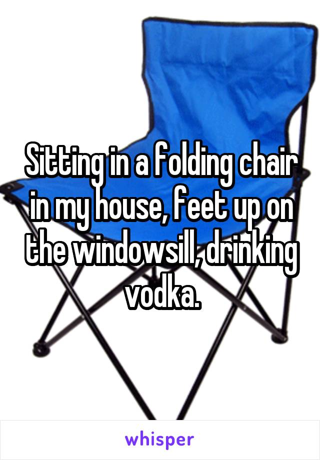 Sitting in a folding chair in my house, feet up on the windowsill, drinking vodka.