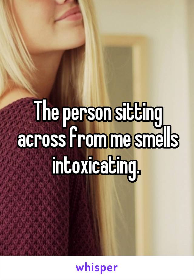 The person sitting across from me smells intoxicating. 