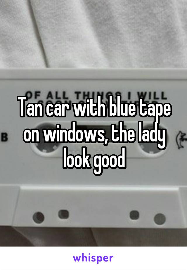 Tan car with blue tape on windows, the lady look good