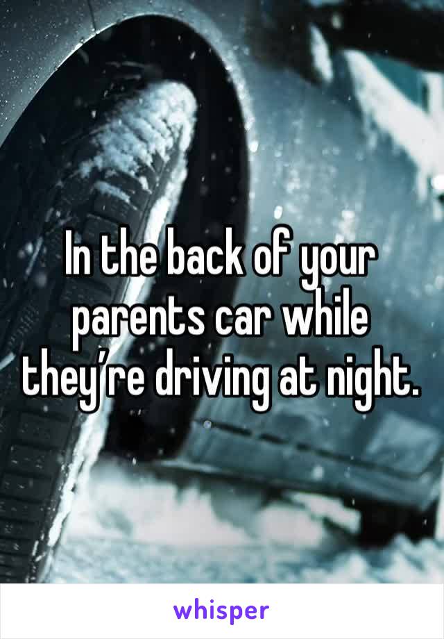 In the back of your parents car while they’re driving at night. 