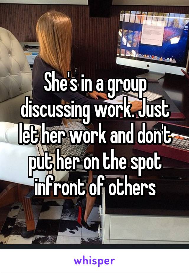 She's in a group discussing work. Just let her work and don't put her on the spot infront of others