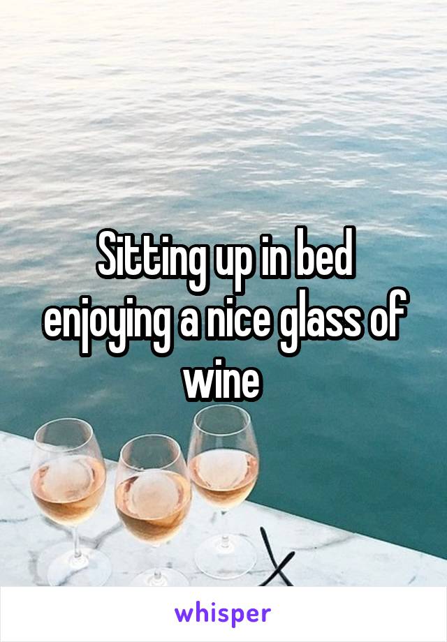 Sitting up in bed enjoying a nice glass of wine 