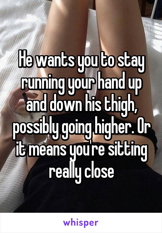 He wants you to stay running your hand up and down his thigh, possibly going higher. Or it means you're sitting really close