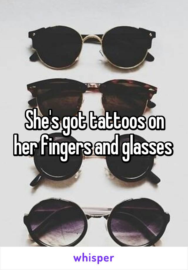 She's got tattoos on her fingers and glasses 